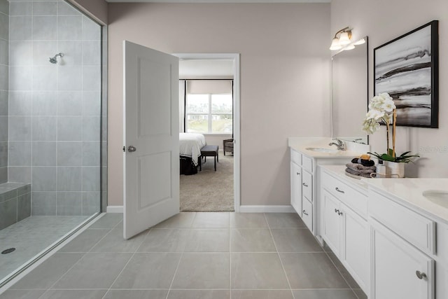 bathroom with tile patterned flooring, vanity, and tiled shower