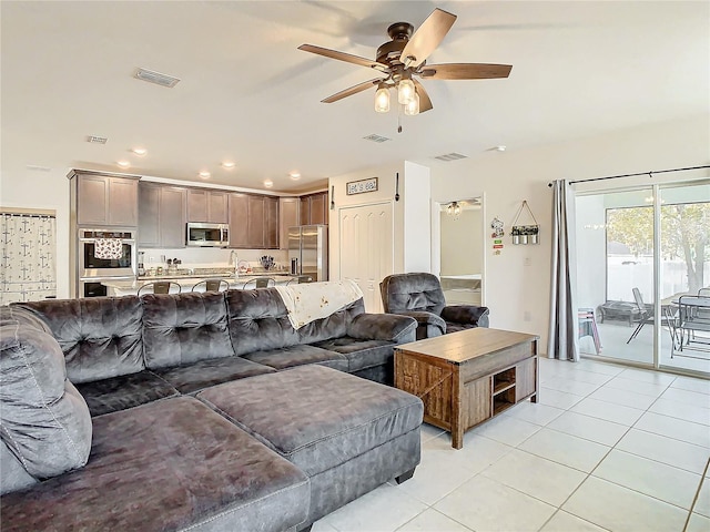 tiled living room with ceiling fan and sink