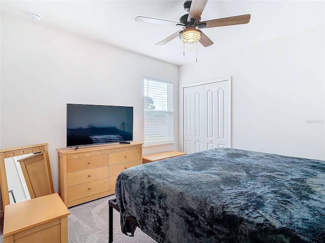 bedroom with ceiling fan, a closet, and light carpet