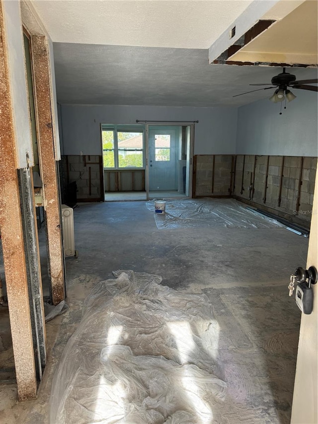 unfurnished room with ceiling fan, radiator heating unit, and a textured ceiling