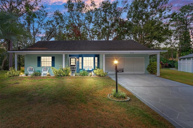 ranch-style home featuring a lawn and a garage