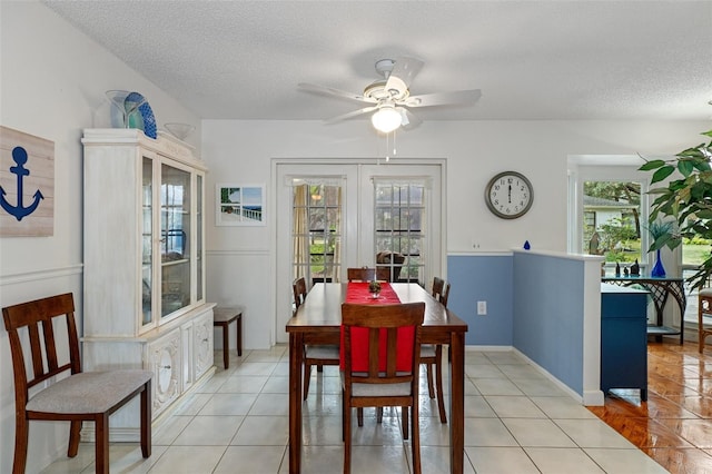 dining area with ceiling fan, french doors, light tile patterned floors, and a textured ceiling