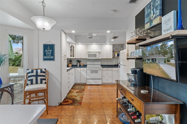 kitchen with white cabinetry, hanging light fixtures, light parquet floors, a textured ceiling, and white appliances