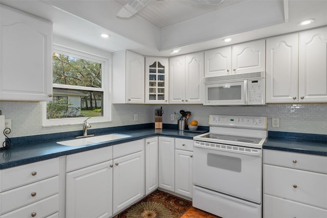 kitchen with backsplash, sink, white cabinets, and white appliances