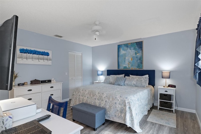 bedroom with wood-type flooring, a closet, and ceiling fan