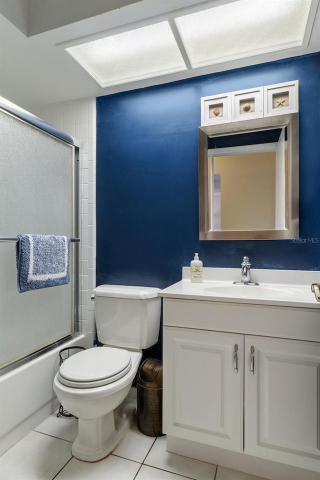 full bathroom with tile patterned flooring, vanity, toilet, and bath / shower combo with glass door