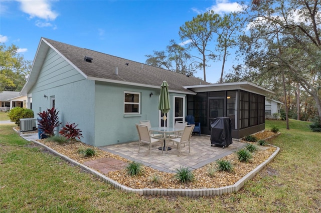 rear view of property with central AC unit, a lawn, a patio area, and a sunroom