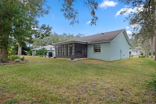 rear view of property with a yard and a sunroom