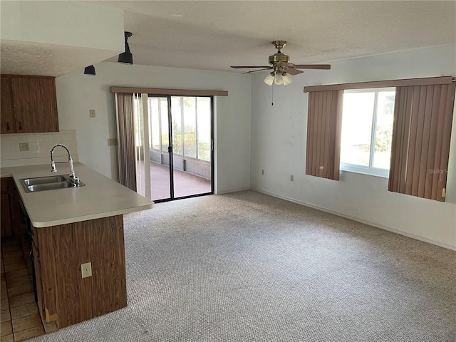 kitchen with a textured ceiling, ceiling fan, and sink