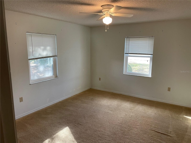 empty room with a textured ceiling, carpet floors, and ceiling fan