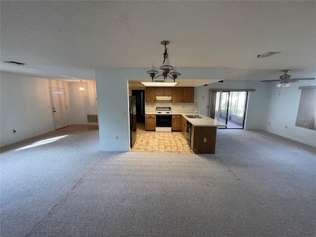 kitchen featuring sink, pendant lighting, a textured ceiling, light carpet, and black appliances