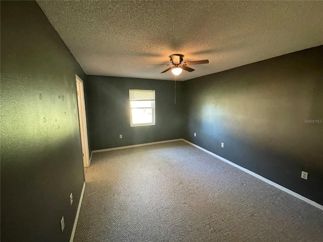 carpeted spare room featuring ceiling fan and a textured ceiling