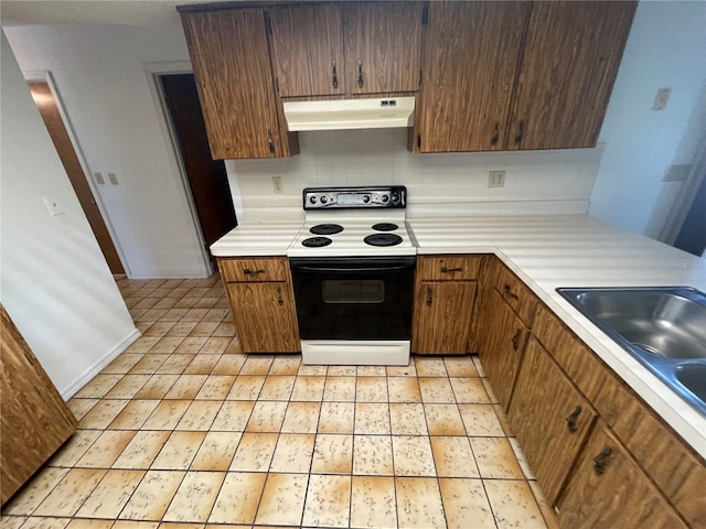 kitchen featuring decorative backsplash, electric stove, and sink