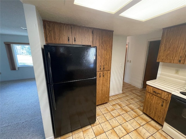 kitchen with black refrigerator, light colored carpet, and white electric range