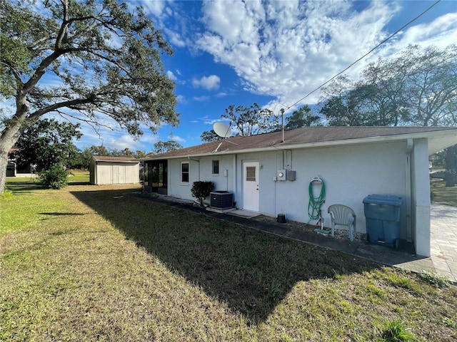 rear view of property with a lawn and central AC unit