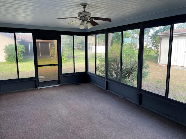 unfurnished sunroom featuring ceiling fan and a healthy amount of sunlight