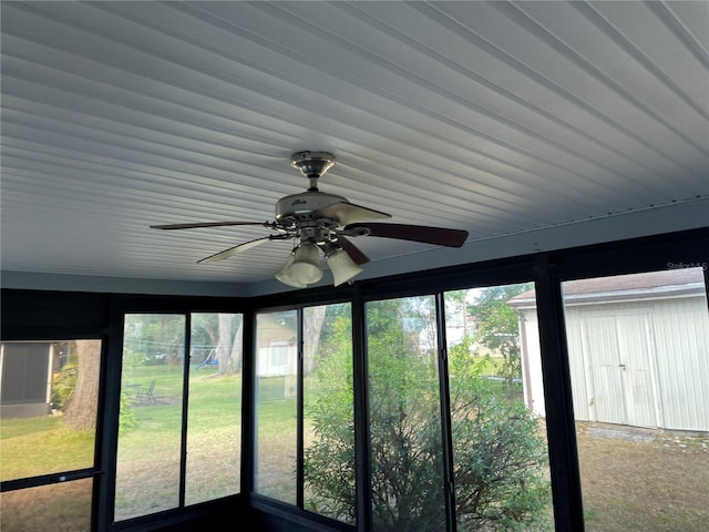 unfurnished sunroom with ceiling fan