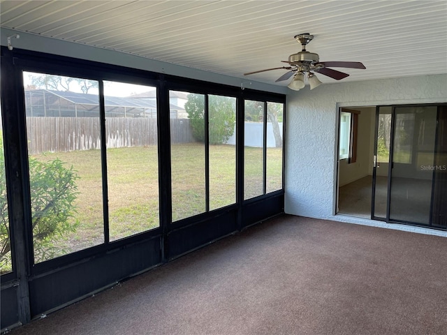 unfurnished sunroom featuring ceiling fan