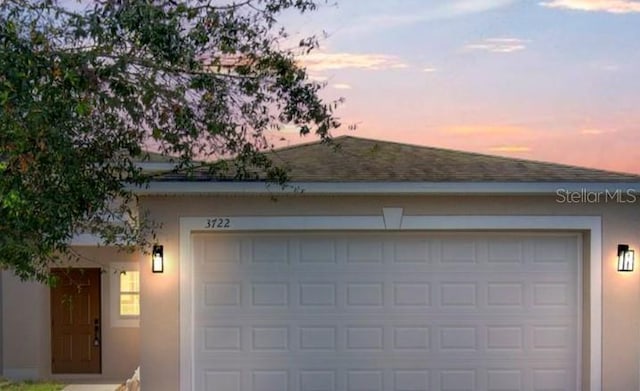 view of garage at dusk