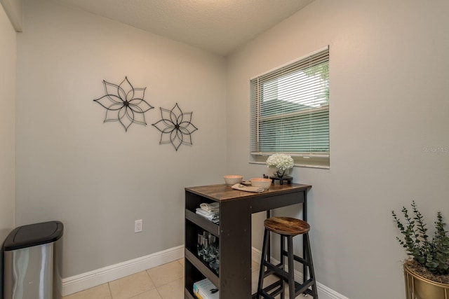 dining room featuring a textured ceiling and light tile patterned flooring