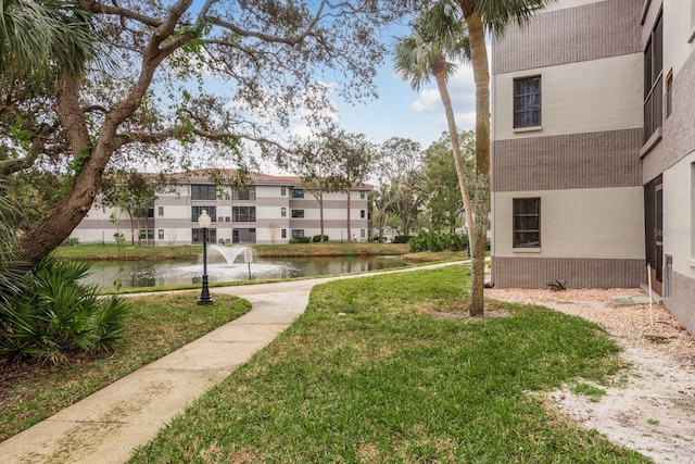 view of community featuring a yard and a water view