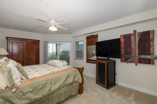 bedroom featuring ceiling fan, light colored carpet, and a textured ceiling