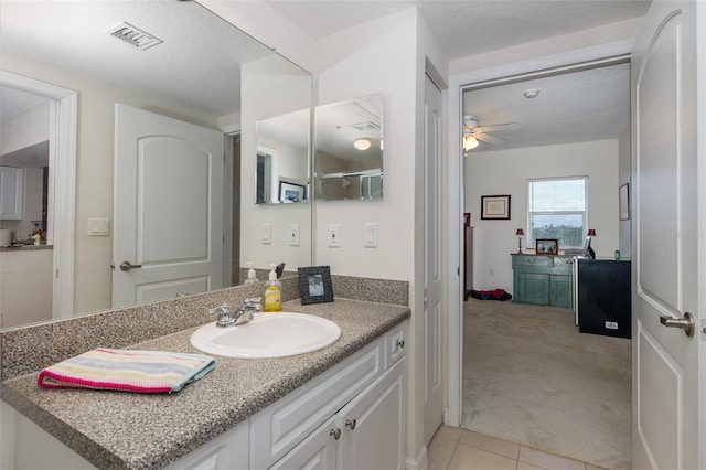 bathroom featuring tile patterned floors, ceiling fan, vanity, and a textured ceiling