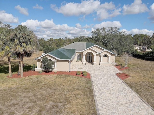 ranch-style house with stucco siding, driveway, and a front yard