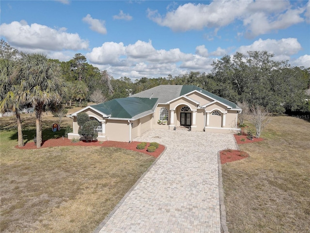 single story home featuring stucco siding, driveway, and a front yard