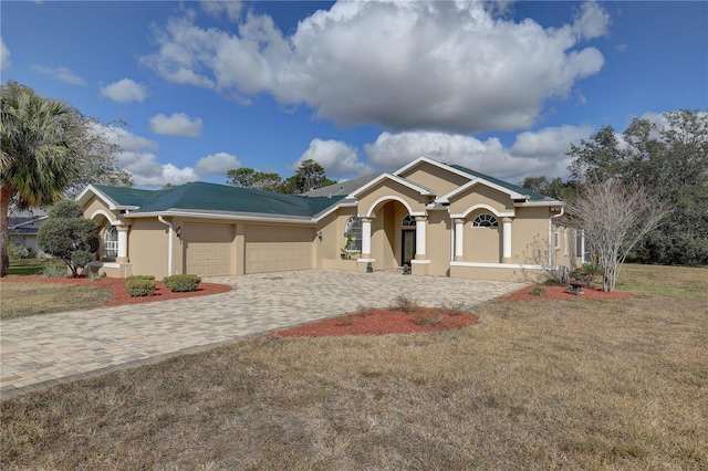 ranch-style home with a garage and a front lawn