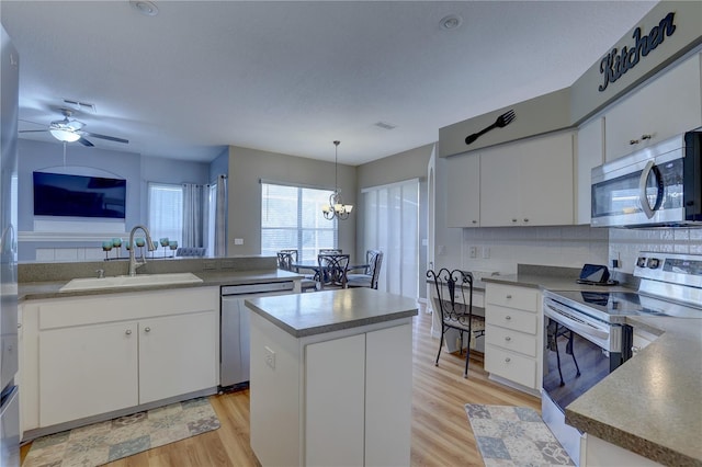 kitchen featuring white cabinetry, sink, a kitchen island, and appliances with stainless steel finishes