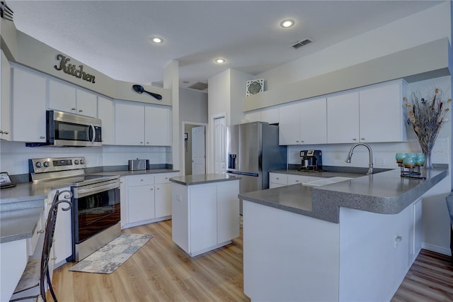 kitchen with white cabinets, a center island, and stainless steel appliances