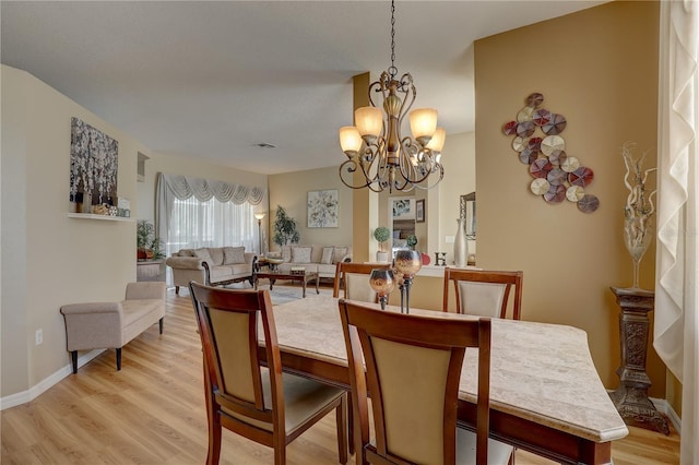 dining room featuring light hardwood / wood-style floors and a notable chandelier