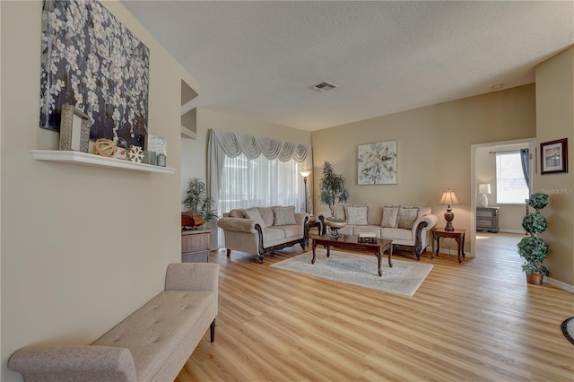 living room featuring a textured ceiling and light hardwood / wood-style flooring