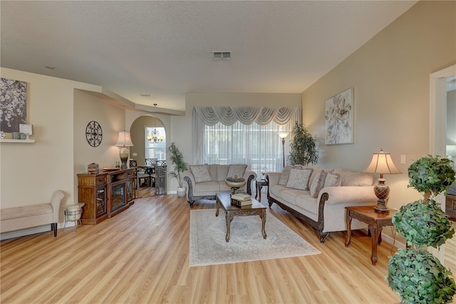 living room with light hardwood / wood-style floors and a textured ceiling