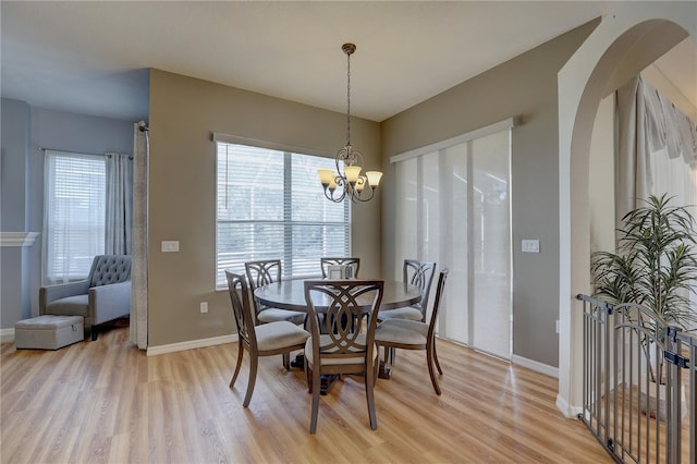 dining area featuring plenty of natural light, a notable chandelier, and light hardwood / wood-style flooring