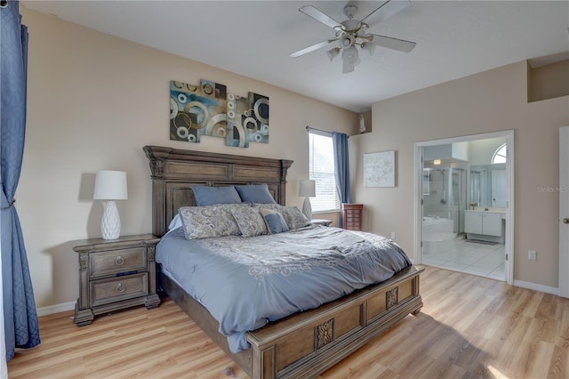 bedroom with ceiling fan, connected bathroom, and light hardwood / wood-style flooring