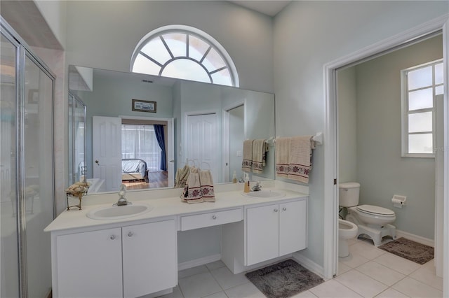 bathroom featuring tile patterned flooring, a bidet, a healthy amount of sunlight, and toilet