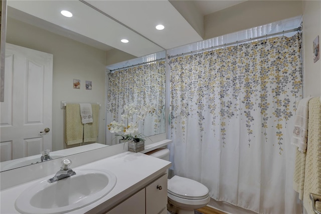 full bathroom with hardwood / wood-style flooring, vanity, toilet, and shower / bath combo with shower curtain