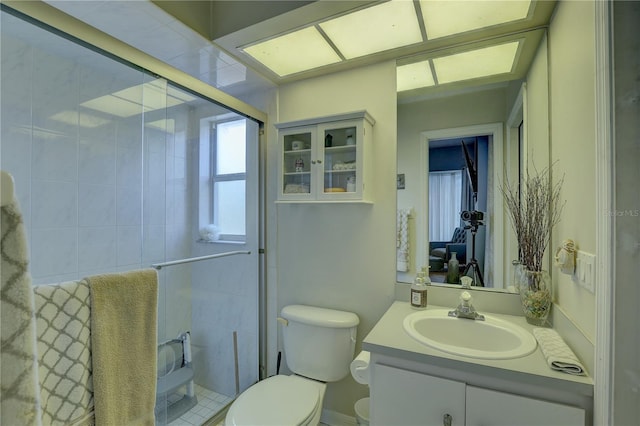 bathroom with vanity, toilet, and a shower with door