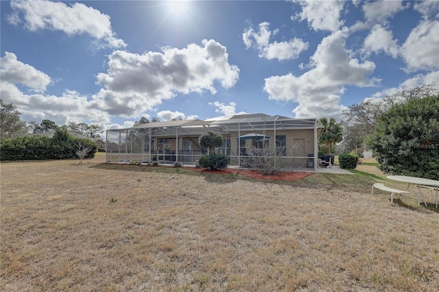 rear view of property with a lanai and a lawn