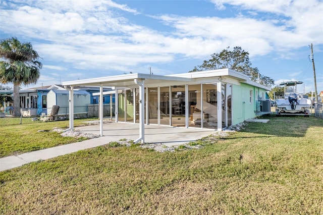 back of property featuring a patio area, a sunroom, and a yard