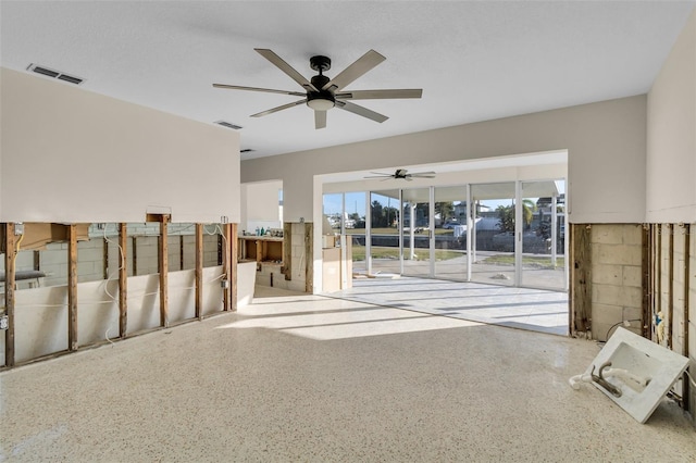 unfurnished living room with a wealth of natural light and ceiling fan