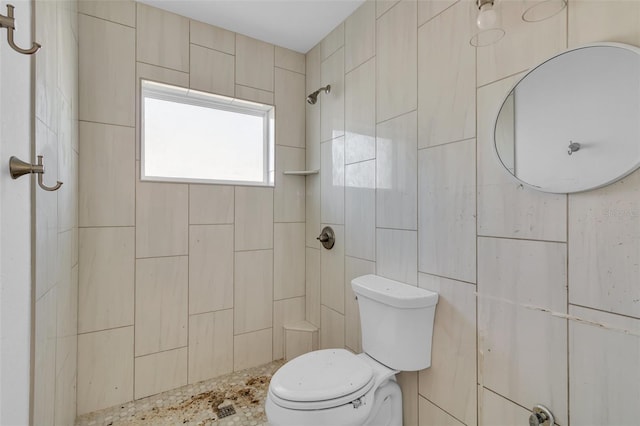 bathroom with toilet and a tile shower