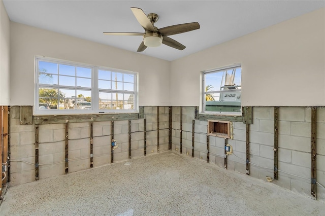 basement with ceiling fan and plenty of natural light