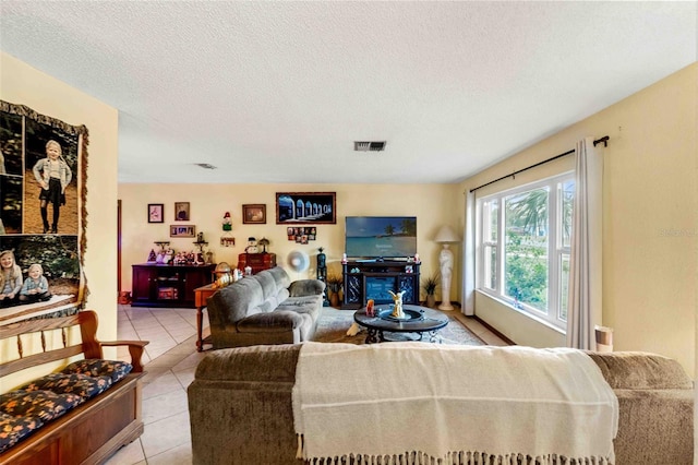 tiled living room featuring a fireplace and a textured ceiling