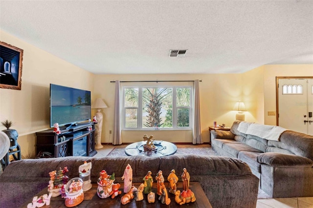 tiled living room featuring a textured ceiling