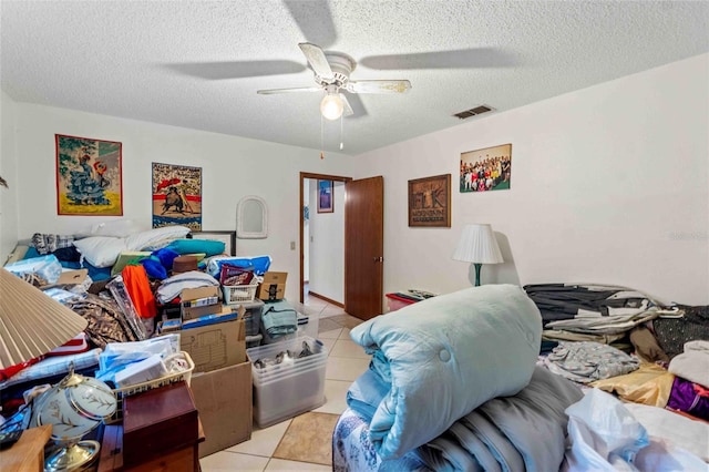 bedroom featuring ceiling fan, light tile patterned flooring, and a textured ceiling