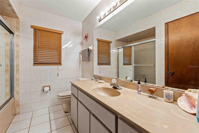 full bathroom featuring tile patterned floors, vanity, tile walls, enclosed tub / shower combo, and toilet