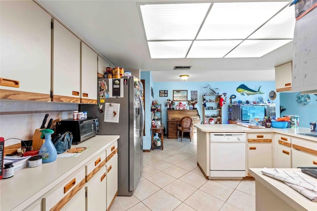 kitchen featuring stainless steel refrigerator, white cabinets, white dishwasher, and light tile patterned floors